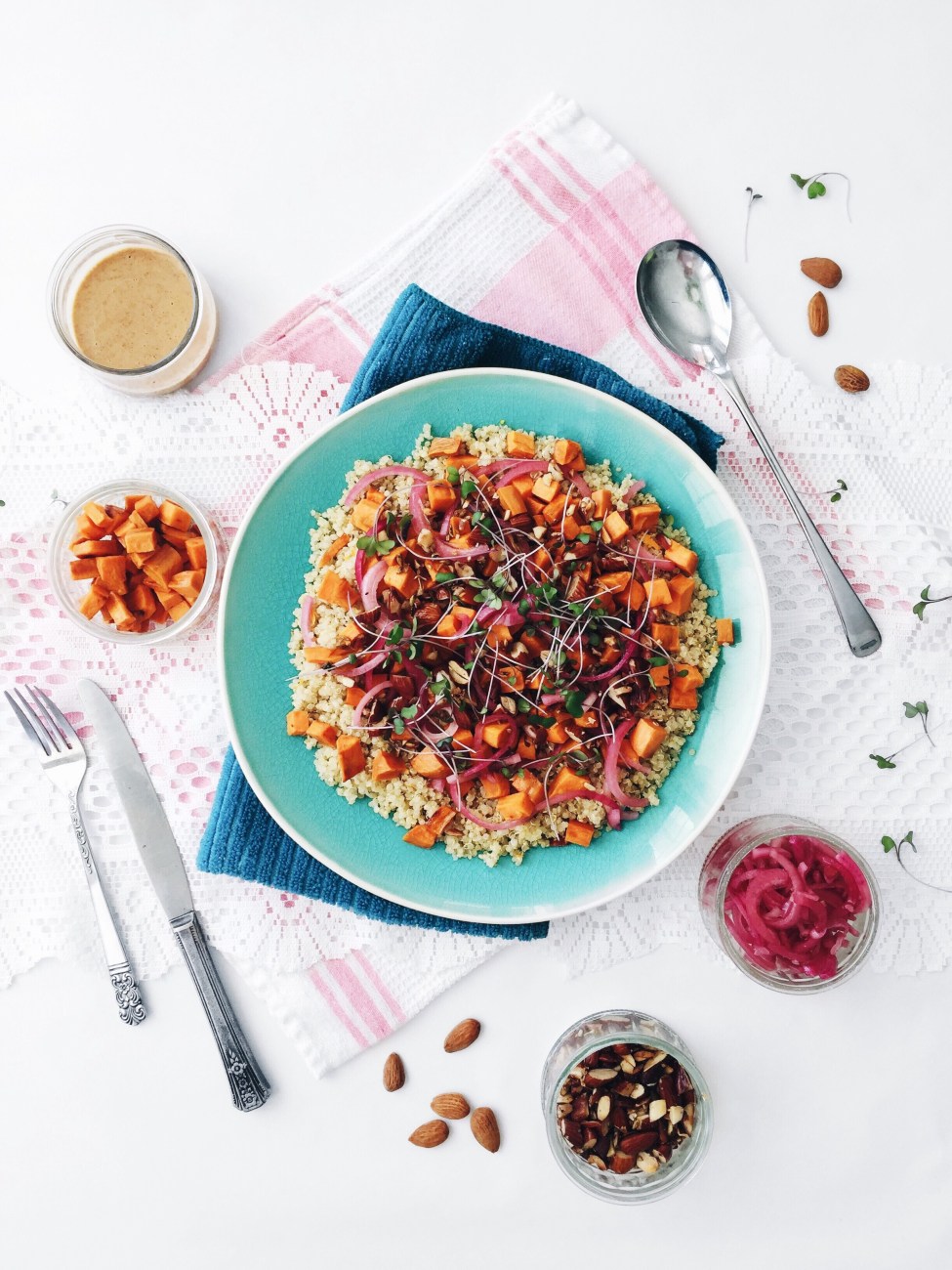 Salade de patates douces rôties au quinoa et oignons rouges, sauce au beurre d'amande et au cumin