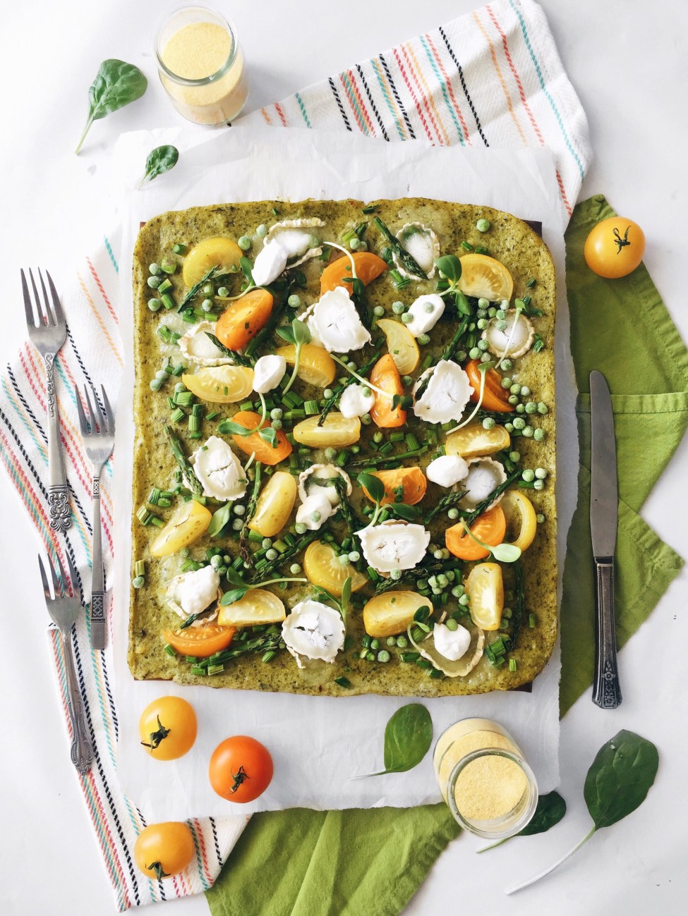 Pizza verte de polenta aux asperges, aux tomates, au fromage de chèvre et au basilic
