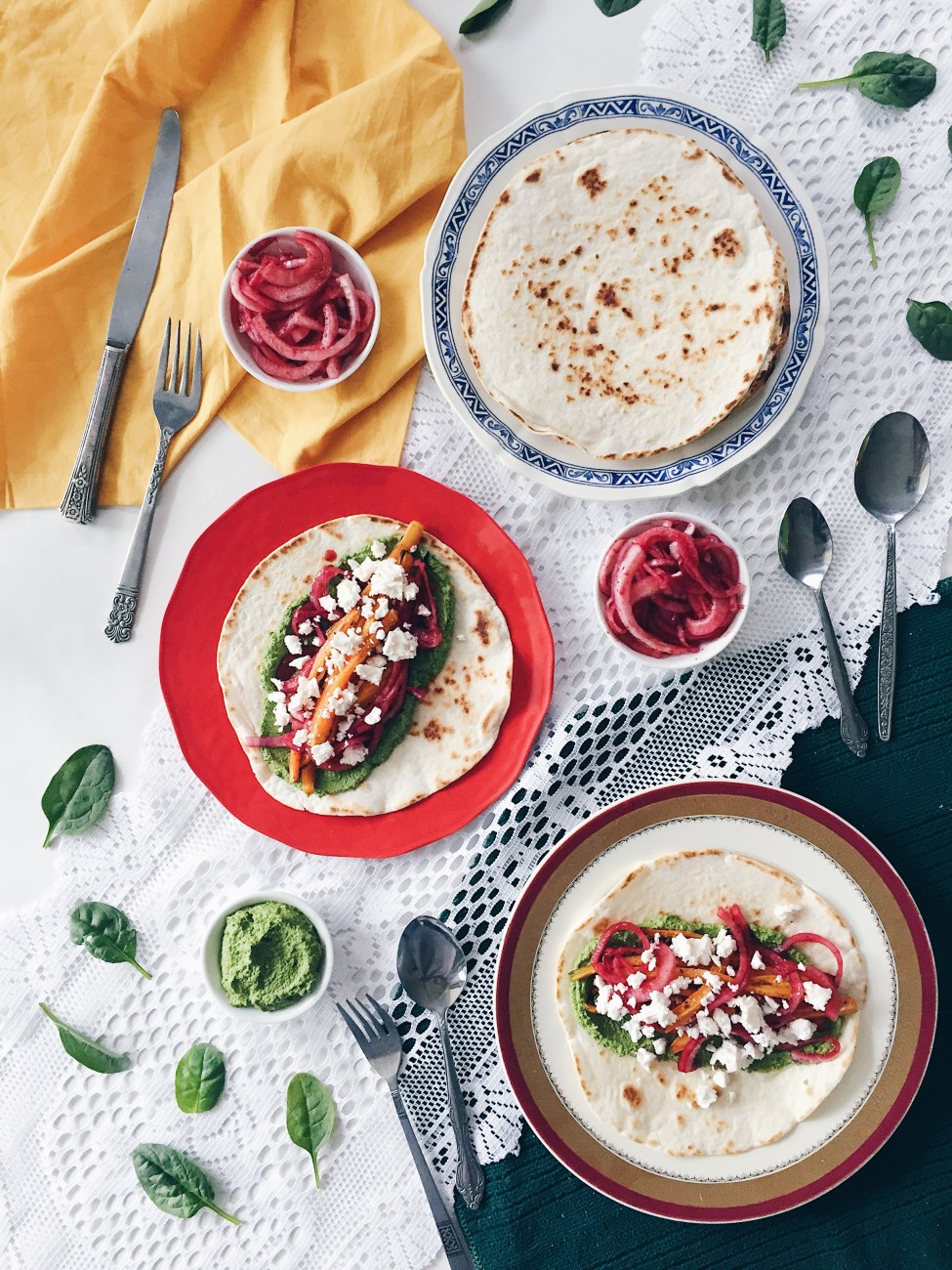 Tacos aux carottes rôties, pesto d'épinards et graines de citrouille, feta, menthe, oignons marinés et crème sûre