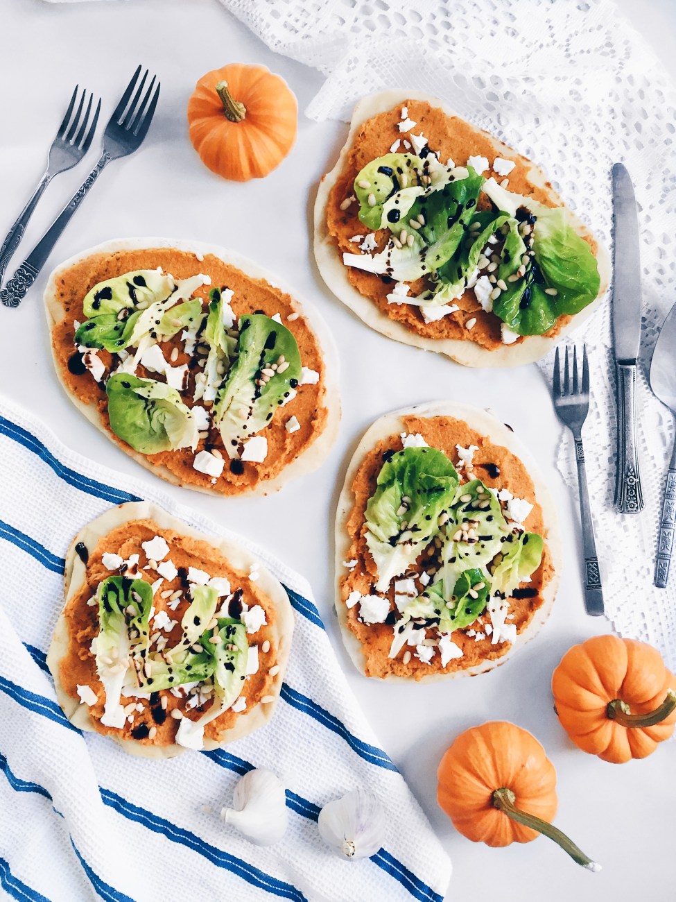 Pizza à la citrouille, cumin, feta, noix de pin et laitue