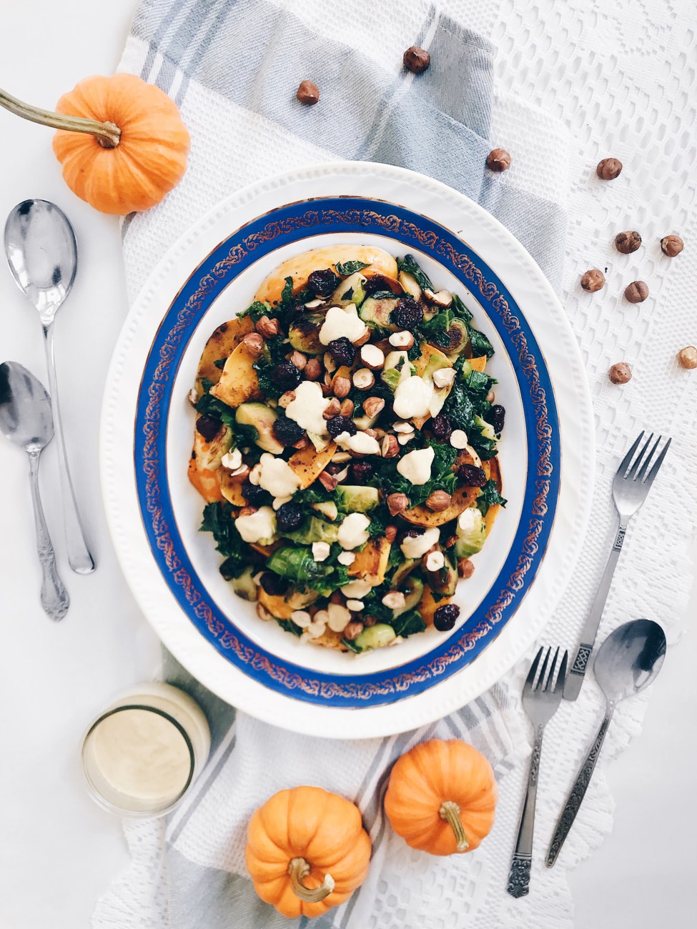 Salade de courge rôtie, choux de bruxelle, kale, canneberges, noisettes et sauce crémeuse
