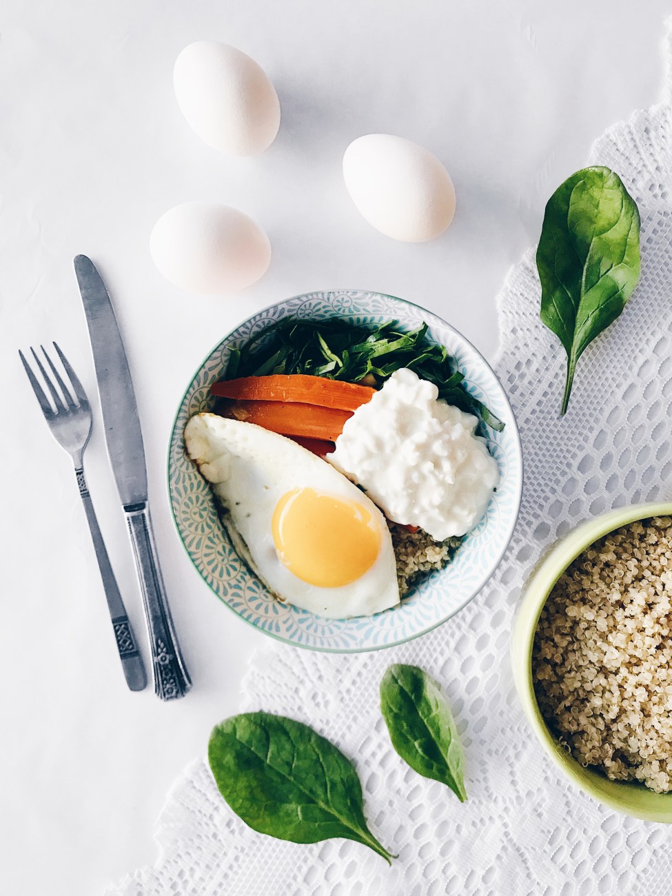 Bol de quinoa déjeuner aux carottes, épinards, fromage cottage et oeuf au plat